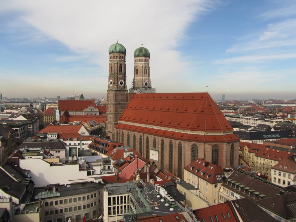 Dieses Stadtpanorama zeigt die berühmte Frauenkirche in München inmitten eines weitläufigen Häusermeers.